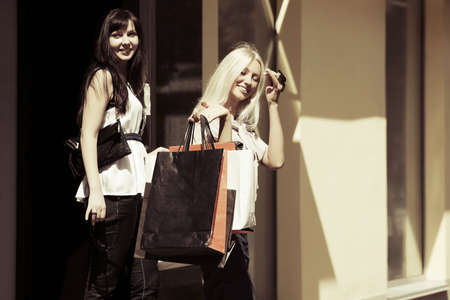 Two happy young women with shopping bagsの写真素材
