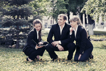 Young business people with laptop in a city parkの写真素材