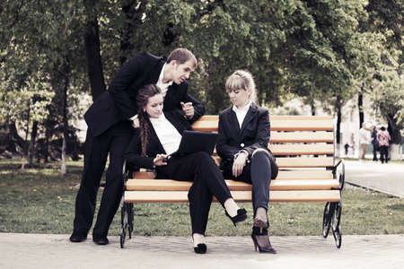 Young business people with laptop in a city parkの写真素材
