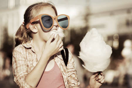 School girl eating cotton candyの写真素材