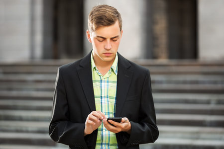 Young man calling on the mobile phone outdoorの写真素材