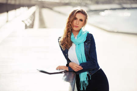 Young fashion blond woman walking on the city streetの写真素材