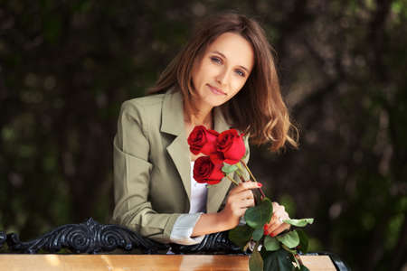 Happy young fashion woman with red rosesの写真素材