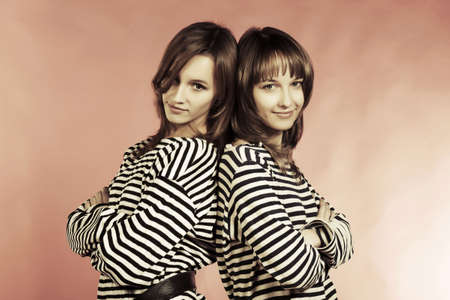 Two young fashion girls in a striped shirtsの写真素材