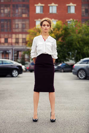 Young fashion business woman standing on the car parkingの写真素材