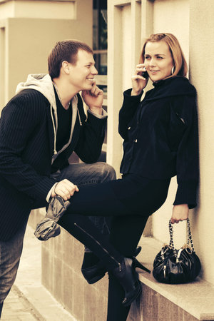 Young fashion woman with handbag calling on cell phone