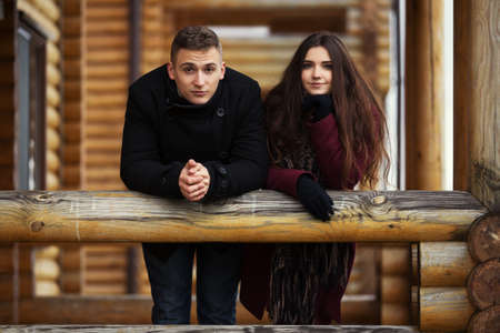 Happy young fashion couple standing on the porch of cottageの写真素材
