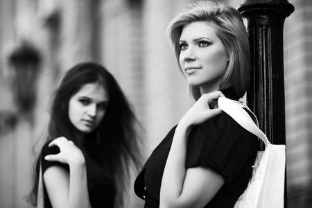 Two happy young fashion women on a city streetの写真素材
