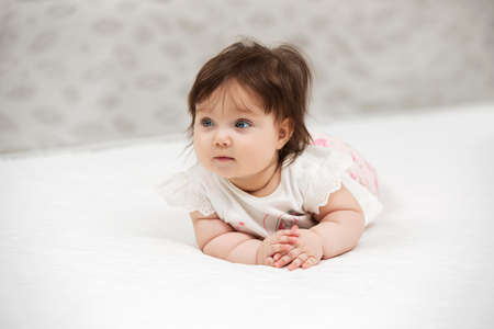 Portrait of baby girl crawling on blanket indoorsの写真素材
