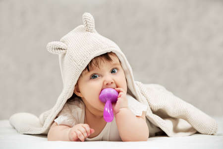 Portrait of baby girl playing with toy on blanket at homeの写真素材