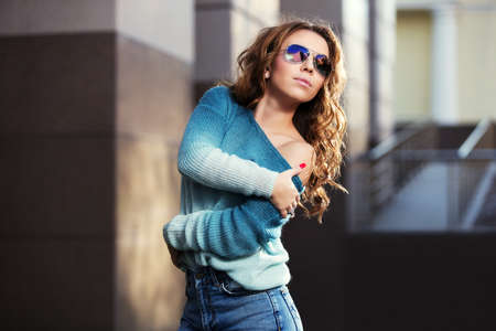 Happy young fashion woman in sunglasses on city streetの写真素材