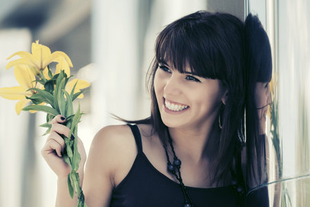 Happy young woman with flowers outdoorの写真素材