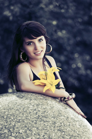 Happy young woman with a flowers on city streetの写真素材