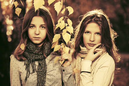 Two young fashion teen girls in autumn parkの写真素材