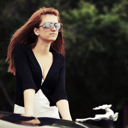 Young fashion woman by retro car outdoor