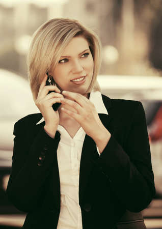Young fashion business woman calling on cell phone outdoorの写真素材