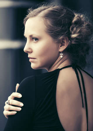 Beautiful fashion woman in black dress on city streetの写真素材