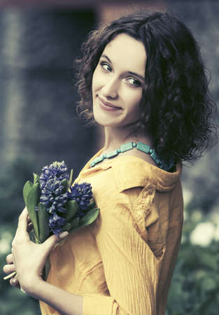 Happy young fashion woman with bouquet of flowersの写真素材