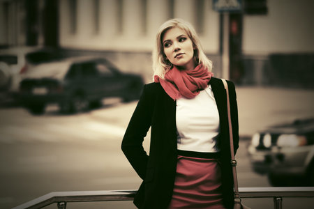 Young fashion business woman walking on city street