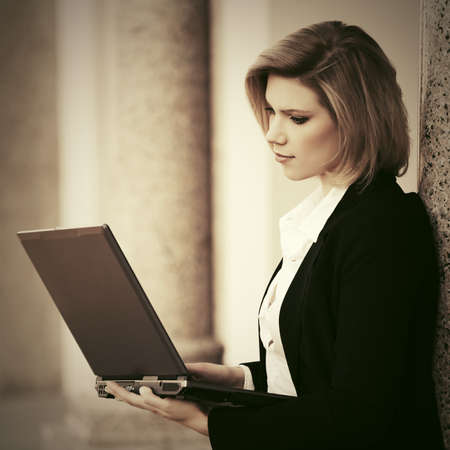 Young fashion business woman with laptop at office buildingの写真素材