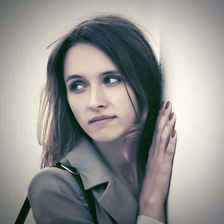 Sad young fashion woman standing at the wallの写真素材