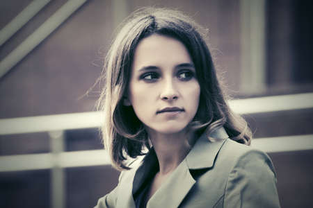 Sad young fashion woman walking on city streetの写真素材