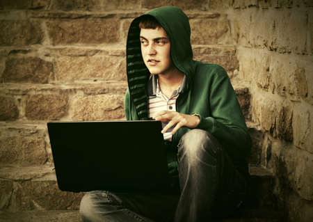 Young man using laptop on the stepsの写真素材