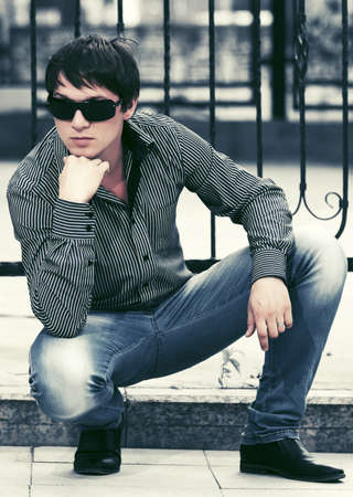 Young fashion man at the cast iron fenceの写真素材