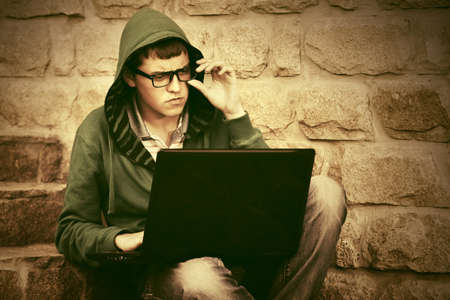 Young man using laptop on the stepsの写真素材