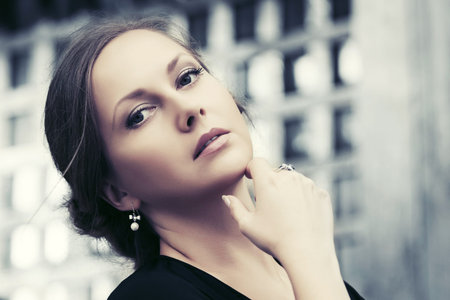 Beautiful fashion woman in black dress walking in a city street