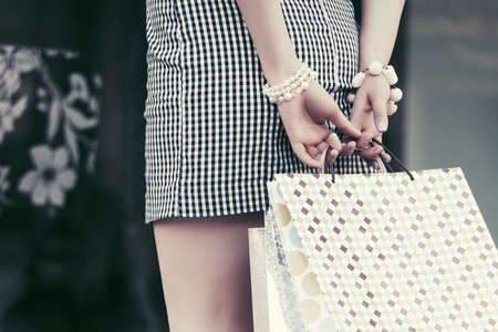 Woman with shopping bags against a mall windowの写真素材
