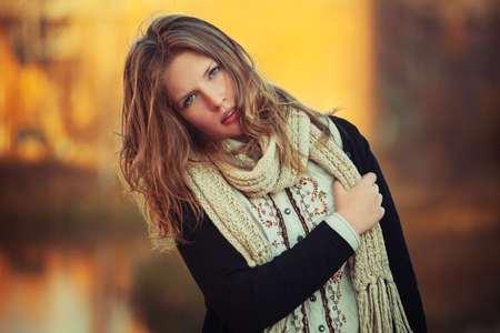Young fashion girl walking outdoor Stylish female teen model in black cardigan and knitted scarf の写真素材