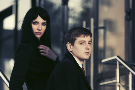Young fashion business couple against office building