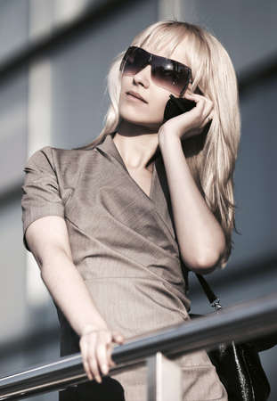 Young fashion business woman talking on mobile phone at office buildingの写真素材