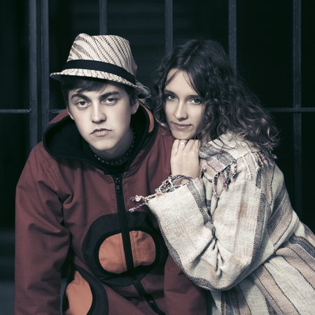 Young fashion hipster couple at the iron fence