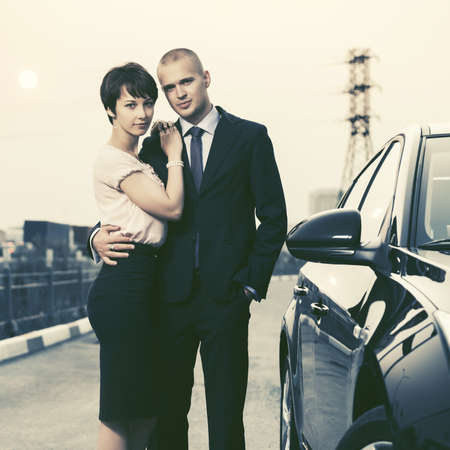 Happy young couple in love next to car. Stylish fashion model outdoorの写真素材