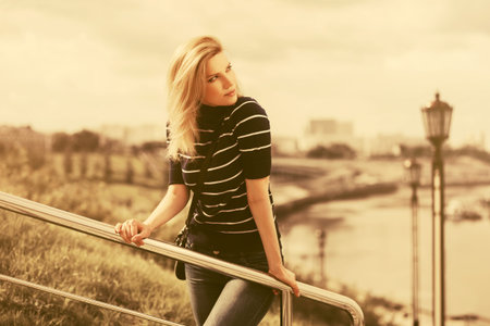 Young fashion woman walking outdoor Stylish female model in striped turtleneck t-shirt and dark blue...