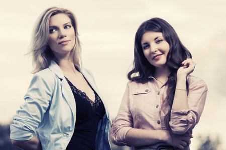 Two happy young fashion women walking outdoorの写真素材