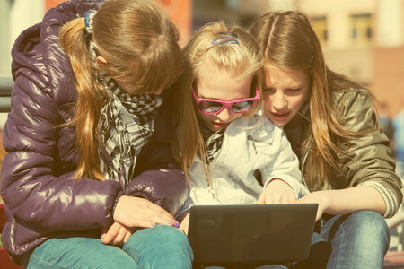 School girls using laptop on the benchの写真素材