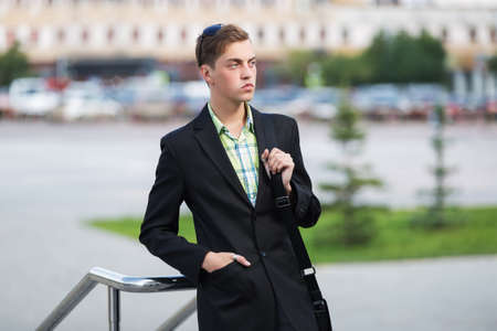 Young handsome business man leaning on railing  Stylish fashion male model in black blazer and and checked shirtの写真素材