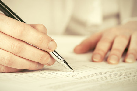Close-up of business woman signing contract