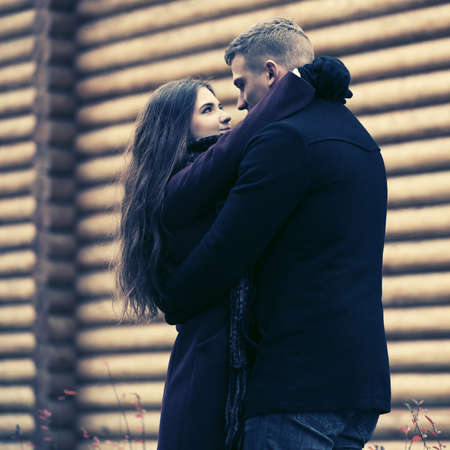 Happy young fashion couple embracing on street Stylish man and woman in classic coatsの写真素材