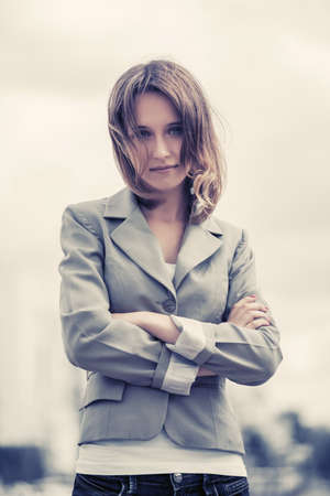 Happy young fashion woman on city street  Stylish female model in gray blazer and white t-shirtの写真素材