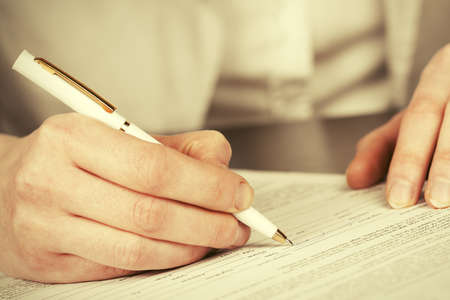 Close-up of business woman signing contractの写真素材