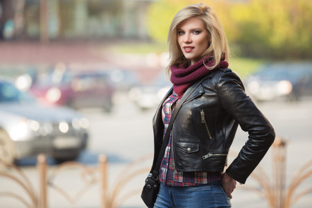 Young fashion blonde woman walking on city street  Stylish female model in black leather jacket and...