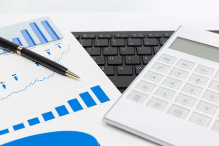Financial accounting stock market graphs and charts analysis pen and calculatorの写真素材