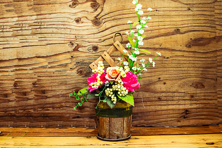 beautiful flower vase on wood table with woodle wall backgroundの写真素材