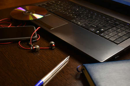 laptop headphones phone pen notebook on the desktopの写真素材