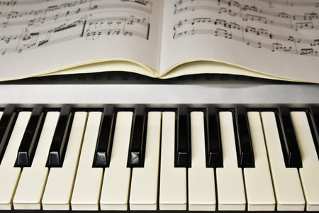 music book lying on the keyboard of the piano