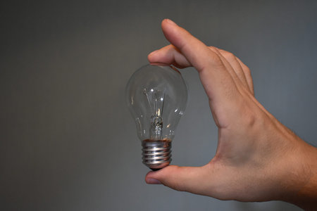 incandescent bulb in hand on empty background